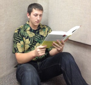 Junior Anthony Boener reads a historical fiction book in a practice room inbetween performances.  Boener reads historical fiction because unrealistic fiction annoys him.   Photo By: Sophia Smith