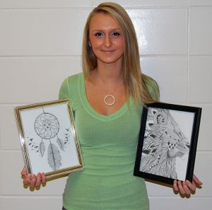  Carlee Hunter holding up her two recent art pieces, she creates her own visions of a dream catcher and a lion. Photo By: Chase Holzwart