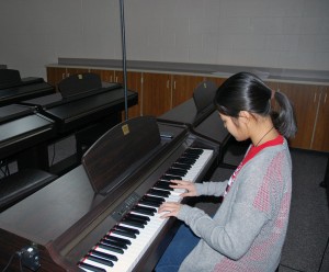 Bee Yongul participates in a new activity that she wouldn't normally participate in Thailand; playing the piano.  Photo By: Chase Holzwart 