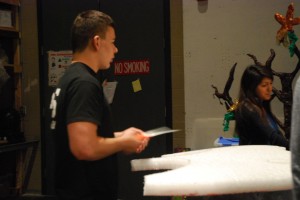 A tech theater senior helps cut styrofoam for the set. Photo by: Cameron Maddox