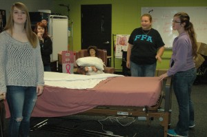 Students in Health Career Class students learning how to properly make a hospital bed Photo By: Taylor Drake