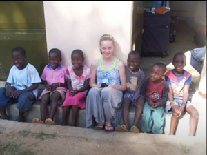 Senior Kizzy Schuler poses for a picture with the Uganda children