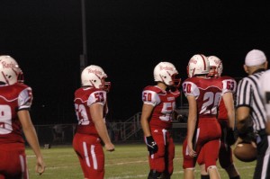 Junior Gabe Bastardo (50), sophomore Graham Chapmen (53), and sophomore Jeremy Drudge (20) prepare to get into position. Photo contributed by: Chelsea Baca.