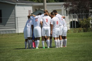 The varsity team huddles together before start of the game.